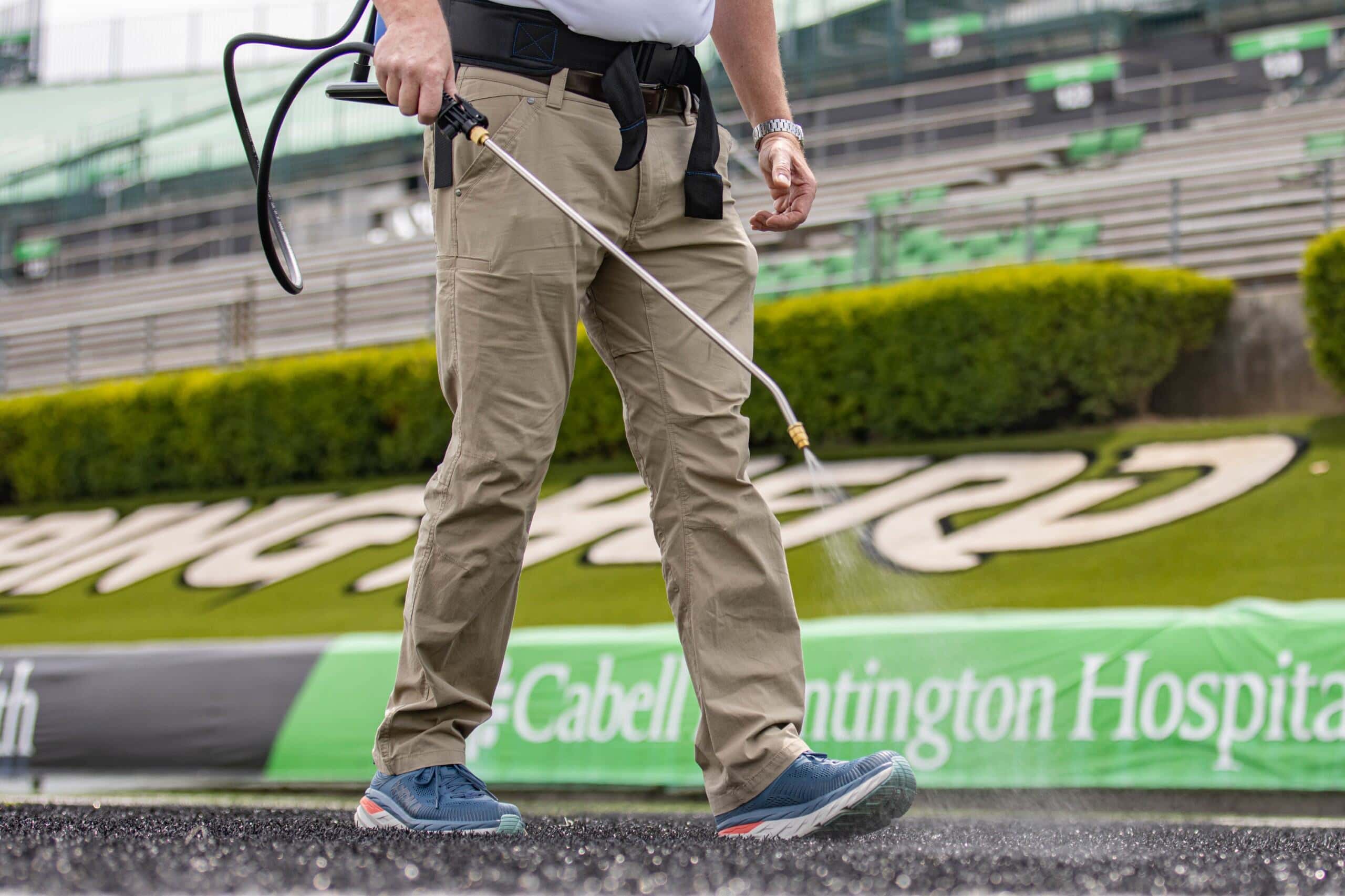 Man spraying chemicals on artificial turf