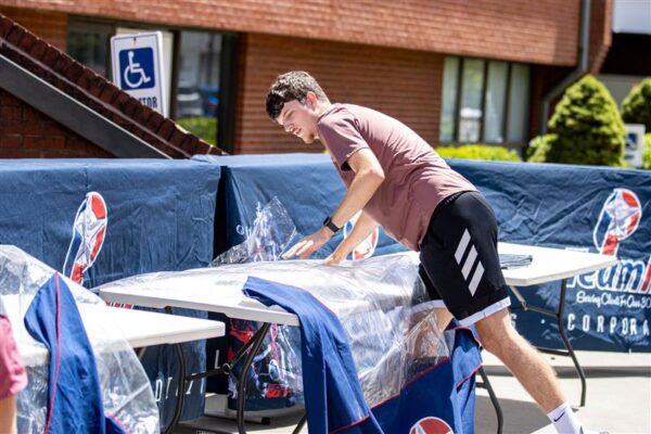 IMG_2254 A guy setting up a merchandise table at an event