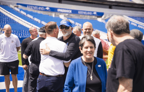 friendly group of people at a sports stadium celebrating and socializing, youth and seniors enjoying a community event, sunny day at the arena. Featuring Lexington's Mayor Gorton