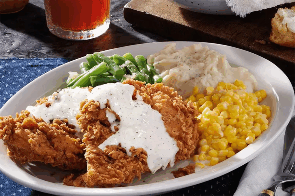 Fried Chicken, green beans, mashed potatoes and corn on a plate.