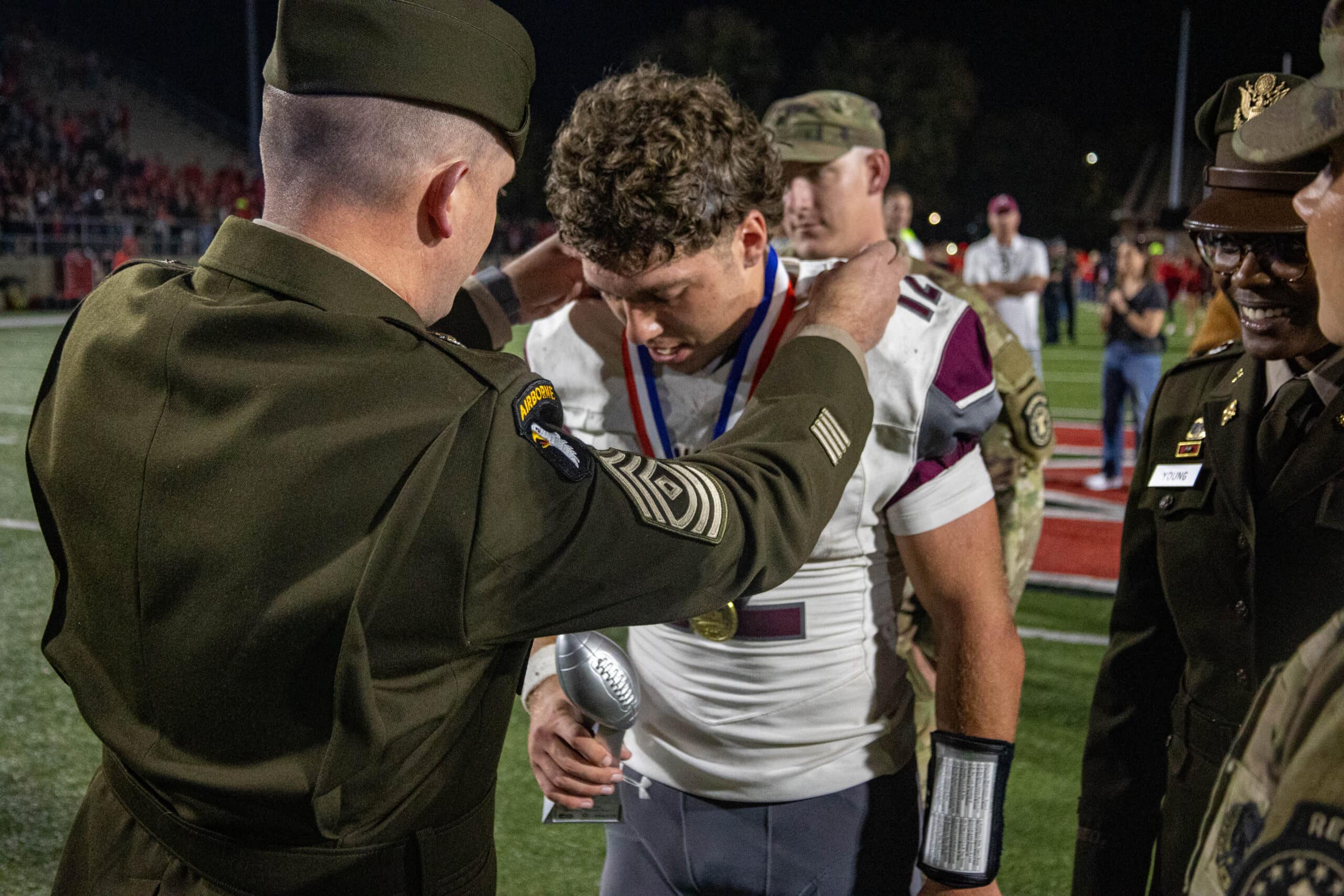 Alcoa Player Medal 2024 Army soldier putting a medal around a football player's neck